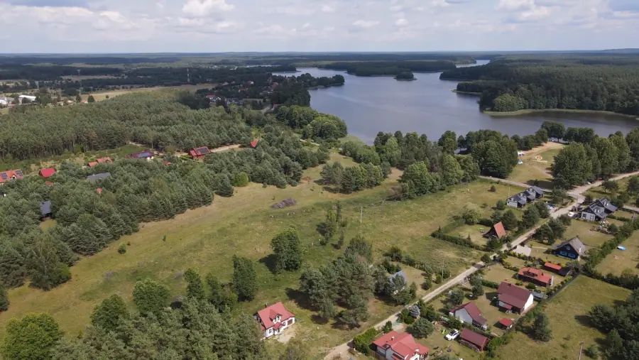 Panorama des Sees bei den Häusern von Kwiat Jabłonki, umgeben von Wald